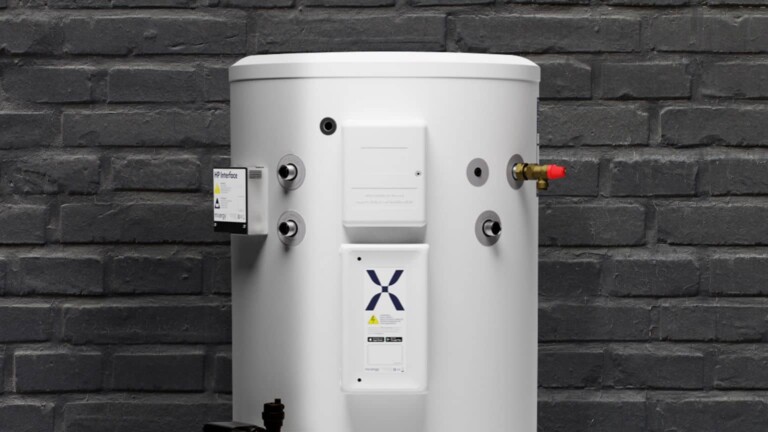 A Mixergy X with Heat pump kit situated against a black brick wall.